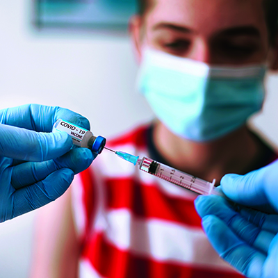 Doctor vaccinating a teenage boy