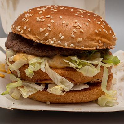 closeup of sloppy assembled or cooked Bigmac burger taken away from McDonalds restaurant